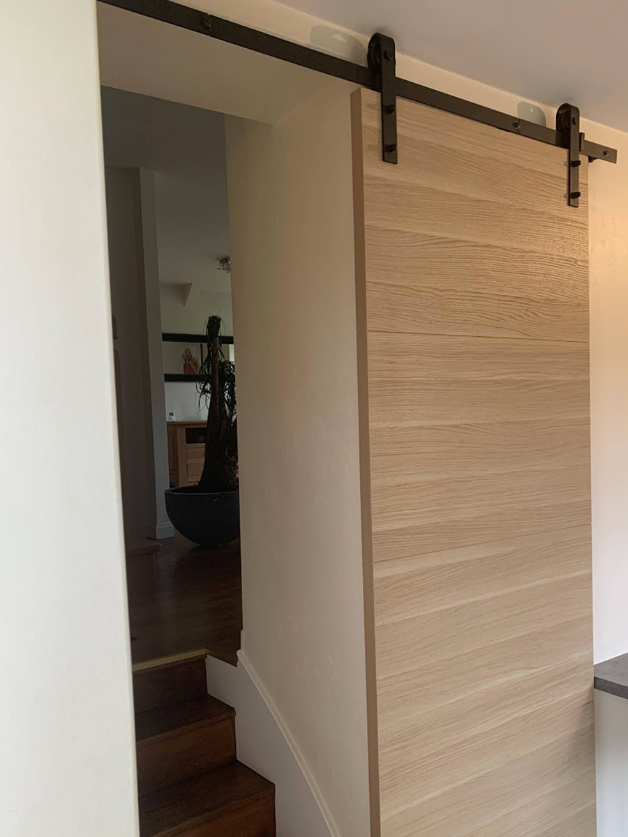 Installation d'une porte coulissante sur un rail style industriel