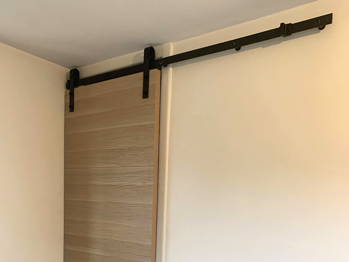 Installation d'une porte coulissante sur un rail style industriel