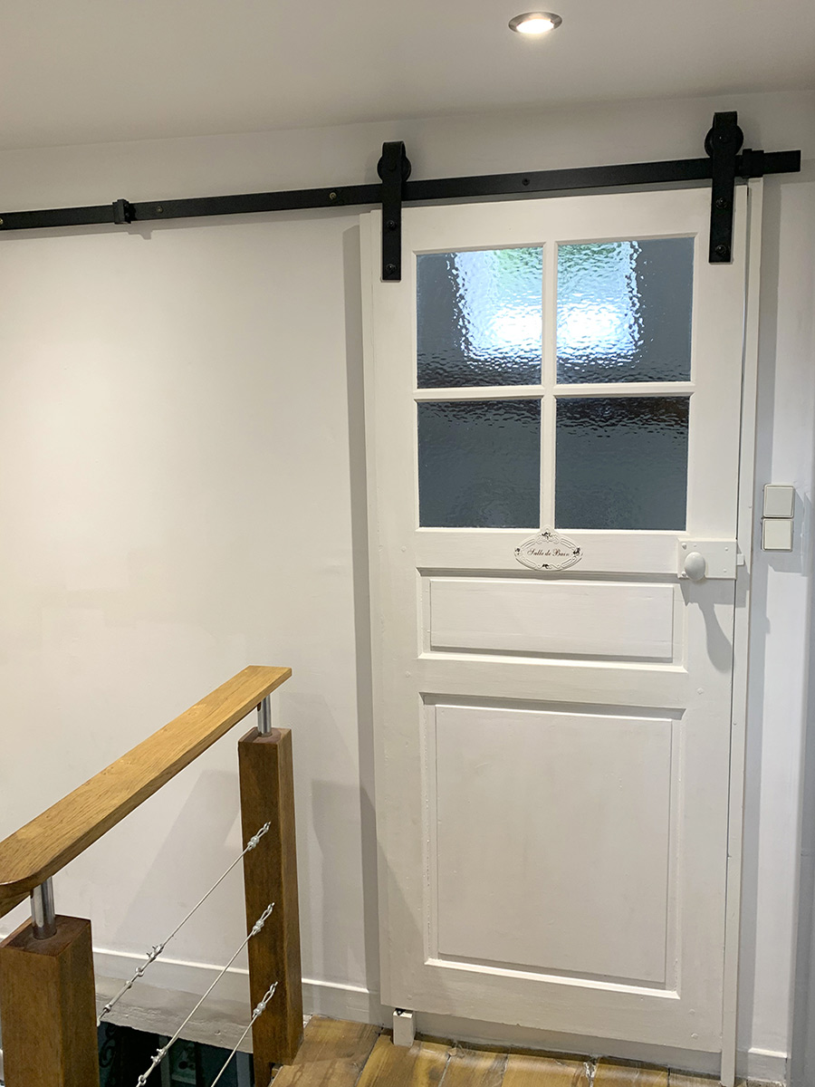 Transformation d'une porte de salle de bain en ouverture coulissante sur rail industriel