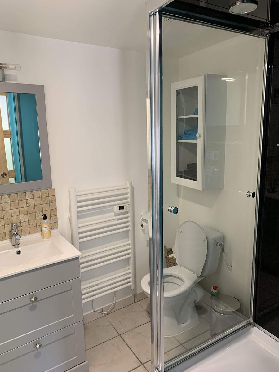 Création d'un espace salle de bain dans un gite locatif : WC, douche, lavabo, rangements, porte coulissante