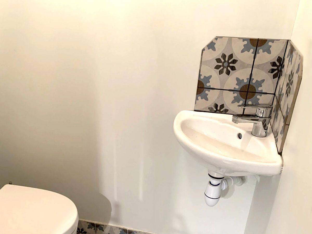 Pose de faïence autour d'un lave mains dans WC