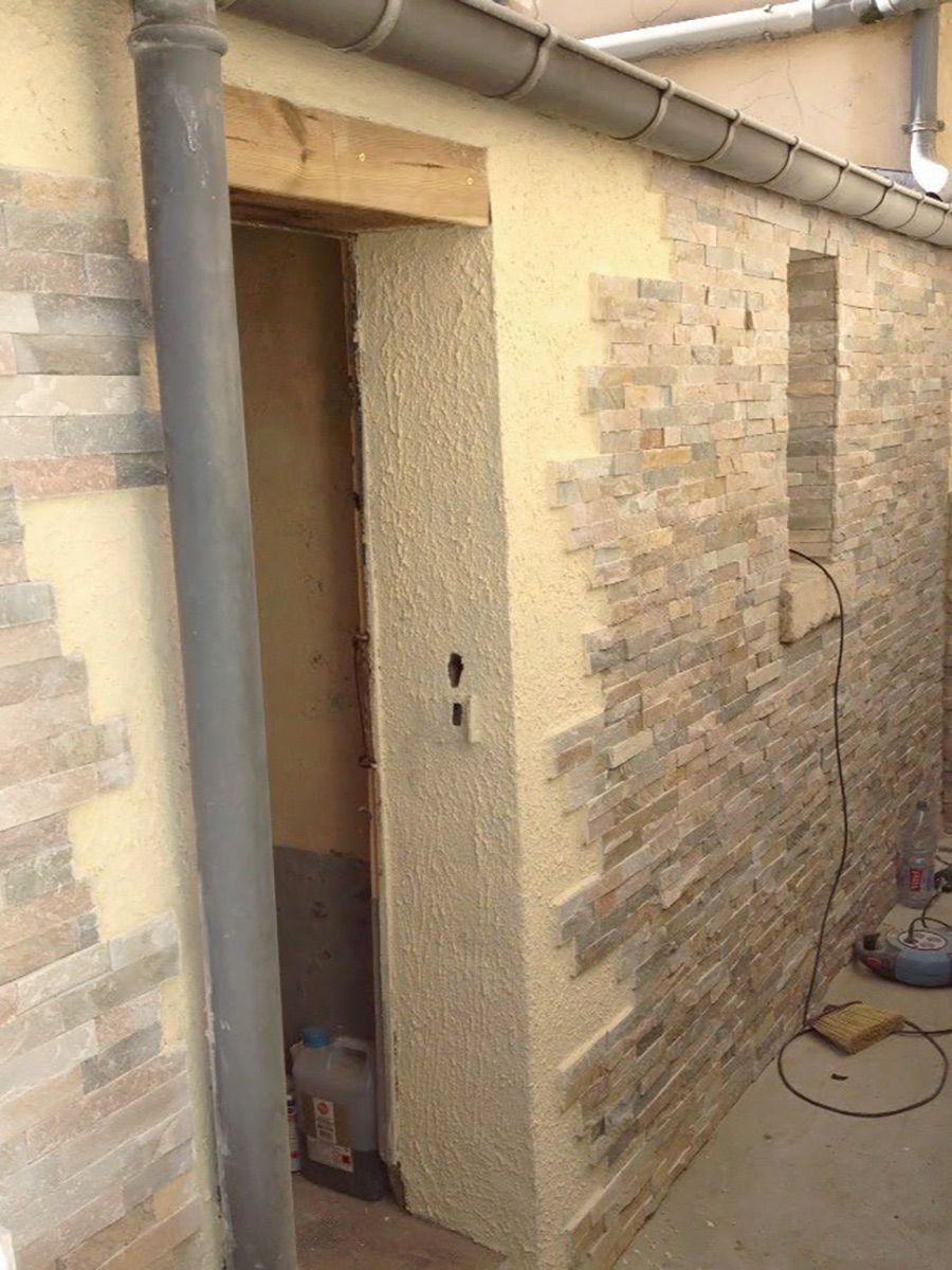 Parement en pierres naturelles et peinture pliolite sur un mur de maison de ville