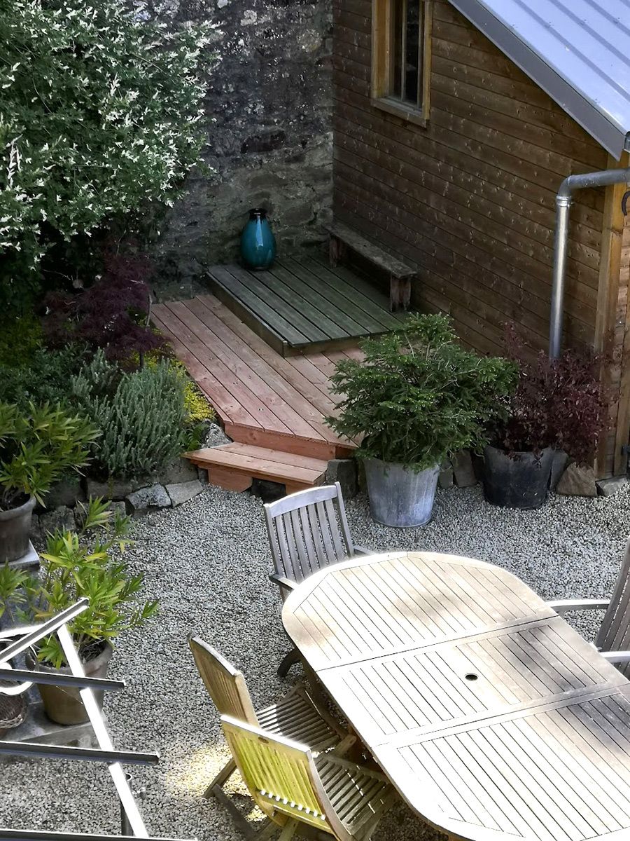 Petite extension de terrasse dans un jardin paysager : vue d'ensemble