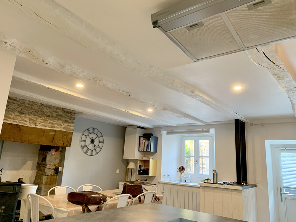 Faux-plafond isolé entre anciennes poutres et peinture