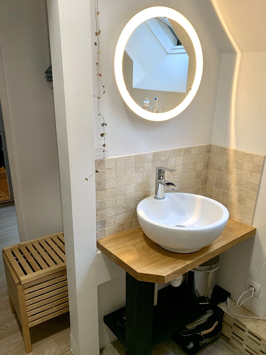 Relookage d'un petit coin salle de bain avec parement en travertin et plan en bambou massif